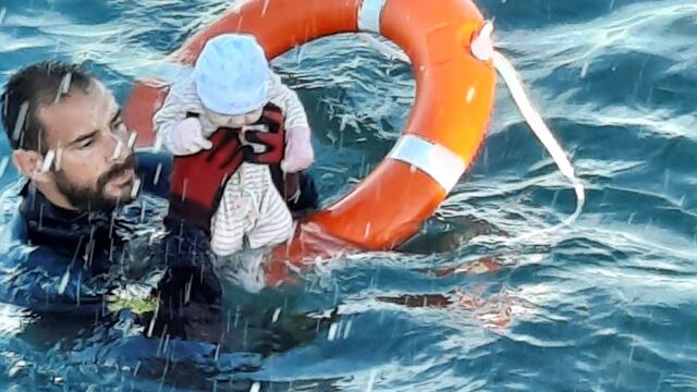 Un miembro de la Guardia Civil rescata a un bebé del agua en Ceuta (Guardia Civil via AP)