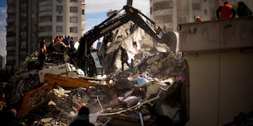 Miembros de rescate de emergencia buscan personas en un edificio destruido en Adana, Turquía.