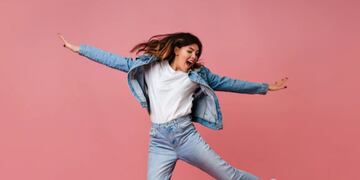 Chica saltando con un outfit de jean.