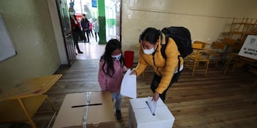Una niña acompaña a una mujer a votar hoy en un centro electoral en Quito (Ecuador). (Foto: EFE/ José Jácome)
