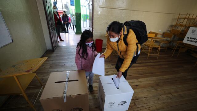 Una niña acompaña a una mujer a votar hoy en un centro electoral en Quito (Ecuador). (Foto: EFE/ José Jácome)